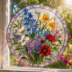 May include: Round stained glass window panel featuring a vibrant floral arrangement. The design includes blue, yellow, red, purple, and white flowers. The panel is framed with a mosaic border and hangs from a chain.