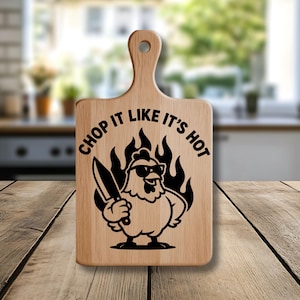 May include: Wooden cutting board with a handle, featuring a cartoon chicken wearing sunglasses and holding a knife, surrounded by flames. The text "CHOP IT LIKE IT'S HOT" is above the chicken.
