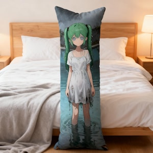 Op de afbeelding: Een lang, rechthoekig lichaamskussen met een illustratie in anime-stijl. De afbeelding toont een meisje met groen haar en een witte jurk dat in het water staat. Het kussen heeft een donkerblauwe lucht als achtergrond.