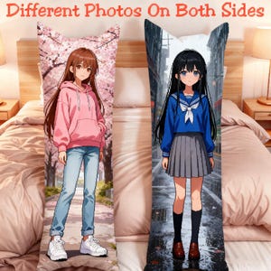 May include: A rectangular body pillow featuring different anime-style illustrations on each side. One side shows a character in a pink hoodie and blue jeans under cherry blossoms. The other side shows a character in a blue sailor uniform and grey skirt.