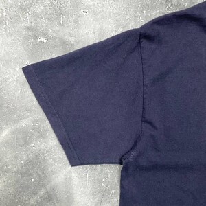 K&ouml;nnte beinhalten: Nahaufnahme eines marineblauen T-Shirt-&Auml;rmels. Der &Auml;rmel besteht aus einem weichen, undurchsichtigen Stoff und hat einen gen&auml;hten Saum. Das Shirt ist einfarbig und scheint ein Freizeitkleidungsst&uuml;ck zu sein.