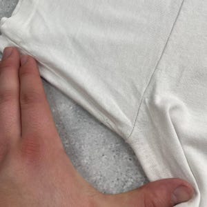 May include: A set of three ceramic mugs with a speckled, matte finish. The mugs are in shades of cream, light gray, and dark gray. Each mug has a simple, minimalist design and a rounded handle.