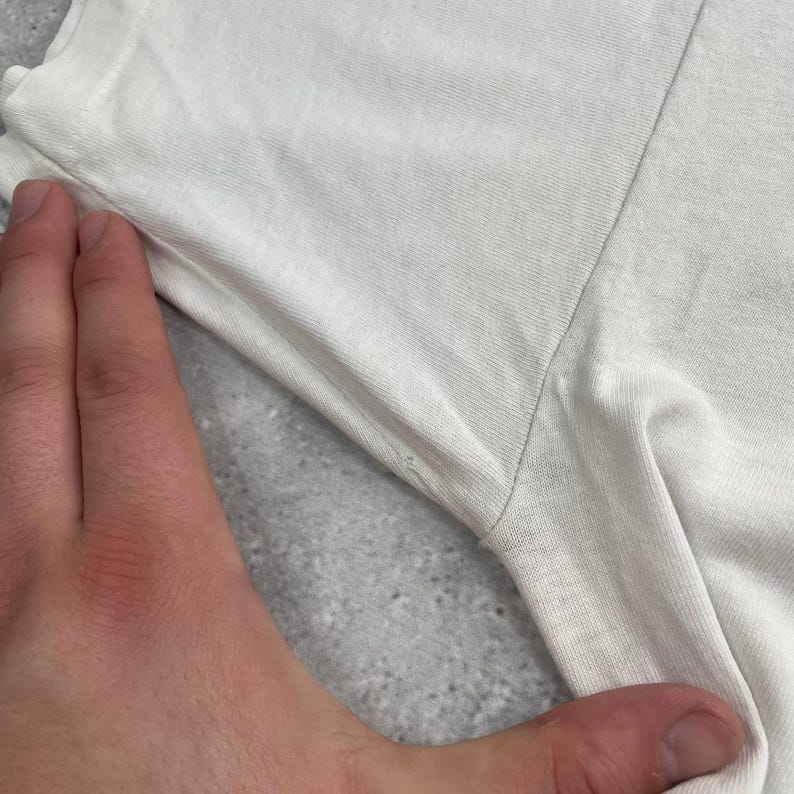 May include: A set of three ceramic mugs with a speckled, matte finish. The mugs are in shades of cream, light gray, and dark gray. Each mug has a simple, minimalist design and a rounded handle.