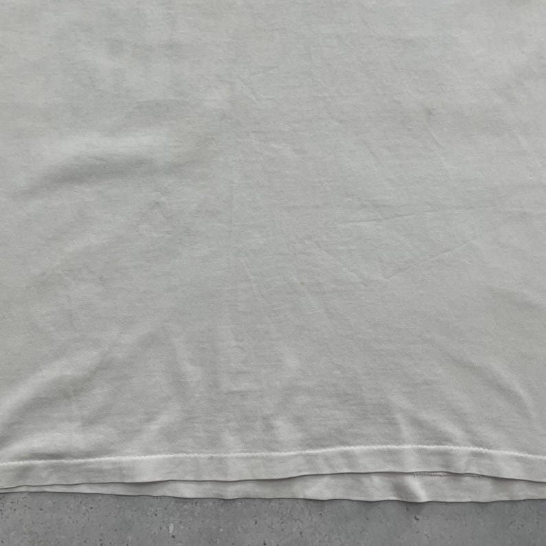 May include: A white ceramic mug with a black handle and the text "But First, Coffee" in a black, handwritten-style font. The mug is on a white surface.