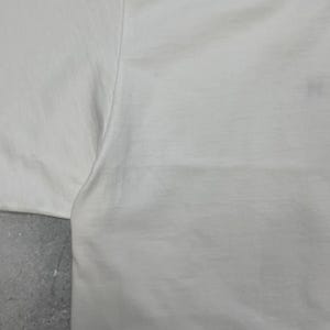 Peut inclure: Une tasse en c&eacute;ramique blanche avec une anse noire et le texte "But First, Coffee" dans un style manuscrit. La tasse est pos&eacute;e sur une surface blanche. La tasse mesure environ 10 cm de haut.