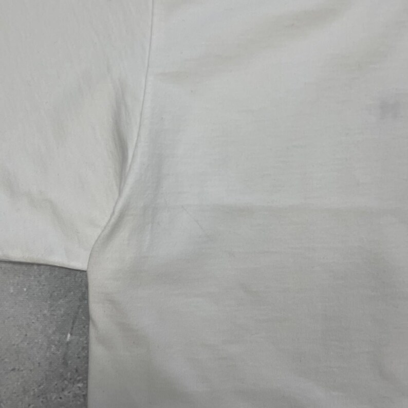 Peut inclure: Une tasse en c&eacute;ramique blanche avec une anse noire et le texte "But First, Coffee" dans un style manuscrit. La tasse est pos&eacute;e sur une surface blanche. La tasse mesure environ 10 cm de haut.