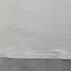 Peut inclure: Une tasse en c&eacute;ramique blanche avec une anse noire et le texte "But First, Coffee" en noir, en gras. La tasse est pos&eacute;e sur une surface en bois. La tasse mesure environ 10 cm de haut.