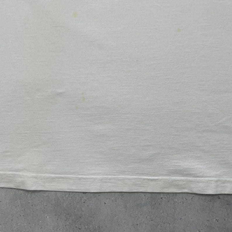 Peut inclure: Une tasse en c&eacute;ramique blanche avec une anse noire et le texte "But First, Coffee" en noir, en gras. La tasse est pos&eacute;e sur une surface en bois. La tasse mesure environ 10 cm de haut.