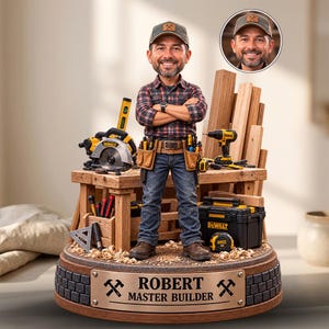 May include: A custom bobblehead figurine of a person wearing a plaid shirt, jeans, and a cap, standing on a wooden workbench with DeWalt power tools, lumber, and a tool belt. A bronze plaque on the base reads ROBERT MASTER BUILDER with hammer icons.