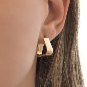 Op de afbeelding: Een set van drie keramische mokken met een gespikkelde, matte afwerking. De mokken zijn in crème, lichtgrijs en donkergrijs. Elke mok heeft een eenvoudig, modern ontwerp en een afgeronde handgreep. De mokken zijn op elkaar gestapeld.