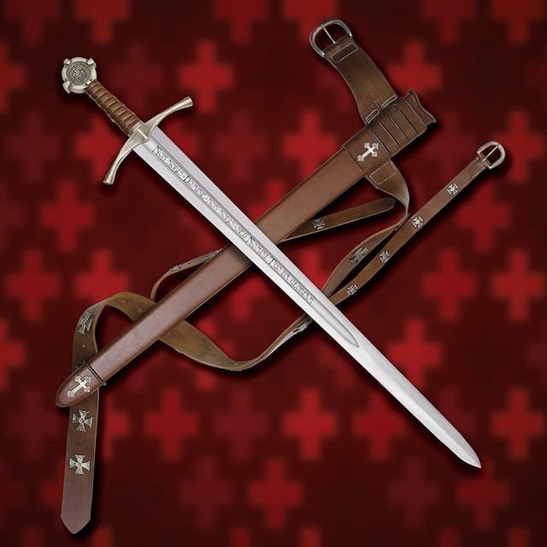 May include: A medieval sword with a silver blade and a brown leather handle and sheath. The sword has a cross-shaped hilt and is accompanied by a matching leather scabbard and belt, adorned with silver crosses. The background is a red pattern.