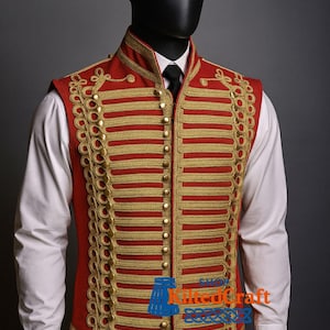 May include: A red military-style vest with gold embroidery and buttons. The vest features vertical gold stripes and decorative gold trim along the edges. It is worn over a white collared shirt and black tie.