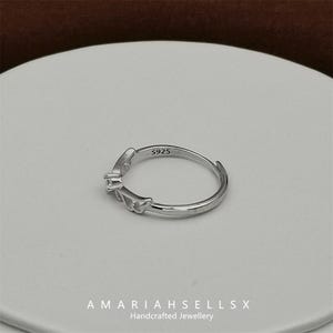 May include: A silver ring featuring a delicate butterfly design. The ring is marked with "S925" on the inside band.