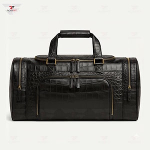 May include: Black duffel bag with a crocodile skin texture. The bag has a top handle, two side zippers, and two front pockets with zippers. The zippers and hardware are gold-colored. The bag is rectangular and appears to be made of leather.