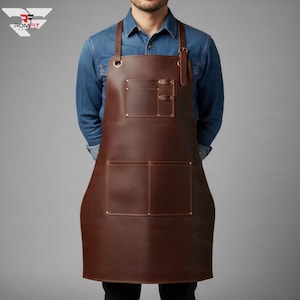 以下が含まれることがあります： 2つの大きなポケットと2つの小さなポケットが付いた茶色の革製エプロン。エプロンには調節可能なストラップと真鍮色のリベットが付いています。エプロンは青いデニムシャツの上に着用されています。