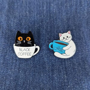 2pcs Funny Cat Coffee Enamel Pin Set – Black Cat in Cup & White Cat Holding Coffee Mug – Cute Pins for Bags, Jackets and Gifts