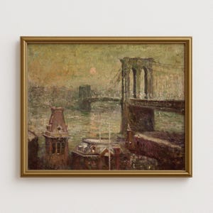 Op de afbeelding: Een antiek olieverfschilderij in een gouden lijst toont een brug over een rivier in de schemering. Het kunstwerk heeft gedempte tinten bruin, groen en grijs, met een vleugje rode zon. Het schilderij roept een vintage esthetiek op.