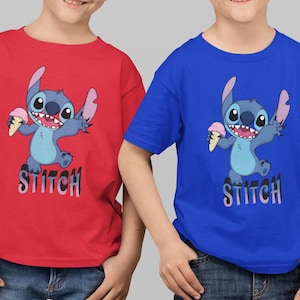 Op de afbeelding: Twee kinderen dragen rode en blauwe t-shirts met het personage Stitch uit Lilo & Stitch. De cartoon Stitch houdt een ijshoorntje vast. Het woord "Stitch" staat eronder gedrukt.