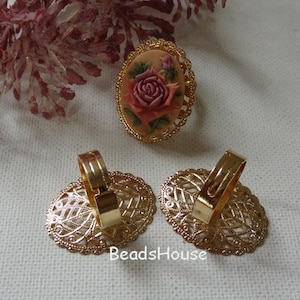 May include: Three gold-tone rings with filigree designs. One ring features a cameo of a pink rose.