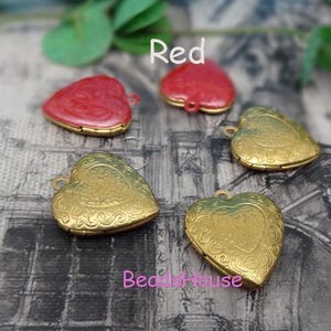 May include: Four heart-shaped locket pendants, two gold and two red. The gold lockets have an ornate design and the red lockets are solid color.