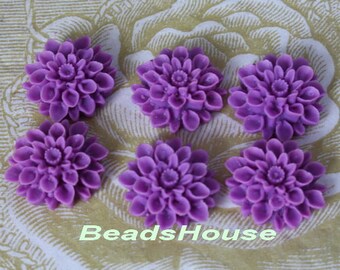 May include: Six purple flower cabochons with a raised, textured design. The cabochons are approximately 1 inch in diameter.