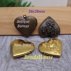 May include: Four heart-shaped locket pendants, two in antique bronze and two in raw brass. Each locket has a hinged opening and a delicate floral design. The lockets measure 28mm x 28mm.
