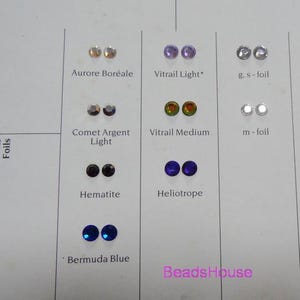 May include: A chart displaying various types of glass beads, labelled with their names and colours. The beads are organised in rows and columns, with each row representing a different type of bead. The beads are all small and round, and they are arranged in a variety of colours, including purple, blue, green, and silver.