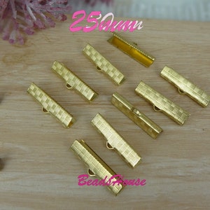 Puede incluir: Cierre de metal dorado para la elaboración de joyas, que mide 25 mm de largo. Los cierres tienen un patrón de cuadrícula y son ideales para agregar un toque de elegancia a collares, pulseras y otros proyectos de joyería.