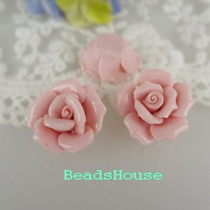 May include: Three pink ceramic rose flower embellishments. The roses have a detailed design and are perfect for adding a touch of elegance to crafts and jewelry.