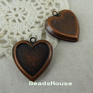 May include: Two antique copper heart-shaped locket pendants with a hinged opening. The lockets have a distressed finish and are ready to be personalized.