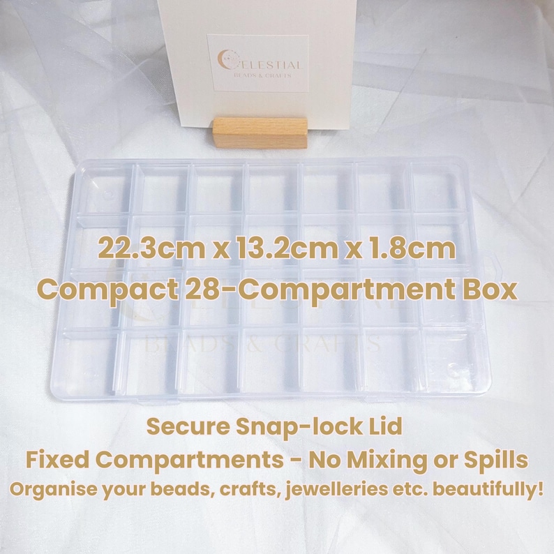 Peut inclure: Bo&icirc;te de rangement transparente rectangulaire &agrave; 28 compartiments, mesurant 22,3 cm x 13,2 cm x 1,8 cm, avec un couvercle &agrave; fermeture s&eacute;curis&eacute;e. Le texte sur la bo&icirc;te indique : "Compact 28-Compartment Box" et "Organise your beads, crafts, jewelleries etc. beautifully!"