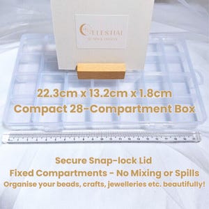 Peut inclure: Bo&icirc;te transparente compacte &agrave; 28 compartiments, mesurant 22,3 cm x 13,2 cm x 1,8 cm, avec un couvercle &agrave; fermeture s&eacute;curis&eacute;e. La bo&icirc;te comporte des compartiments fixes pour &eacute;viter le m&eacute;lange ou les d&eacute;versements. Texte: "Organisez vos perles, travaux manuels, bijoux, etc. magnifiquement!"