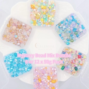May include: Six clear plastic containers filled with colorful beads, arranged in a circular pattern. The beads are in various shapes and sizes, with colors including pink, blue, yellow, and green. Text on the image reads "Mystery Bead Mix Bundle 6 or 12 x 50g Pack."