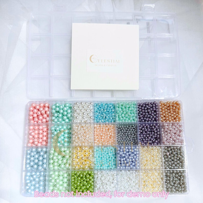 Peut inclure: Une bo&icirc;te de rangement en plastique transparent remplie de perles de fausses perles de diff&eacute;rentes couleurs. Les perles sont dispos&eacute;es dans des compartiments individuels. Une carte blanche avec le texte "Celestial Moon & Earth" est en haut &agrave; droite. Texte en bas : "Beads not included, for demo only".