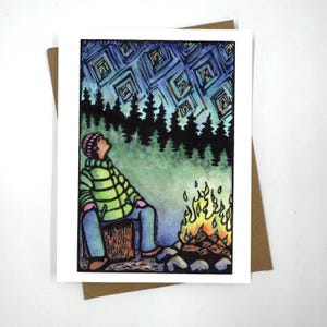 Może przedstawiać: Akwarela przedstawiająca osobę siedzącą przy ognisku pod rozgwieżdżonym nocnym niebem. Osoba ma na sobie zieloną kurtkę i różowy kapelusz. Niebo jest ciemnoniebieskie z białymi gwiazdami. Ognisko jest pomarańczowe i żółte.