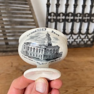 Puede incluir: Un huevera de cerámica blanca con una impresión por transferencia en blanco y negro de un edificio. El texto LUDDENDEN FOOT CONGREGATIONAL CHURCH está impreso en arco alrededor de la ilustración del edificio de la iglesia en la parte frontal.