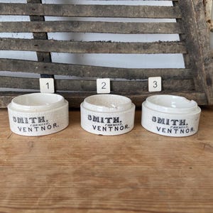 May include: Three white ceramic containers with black lettering that reads "Smith, Chemist, Ventnor".