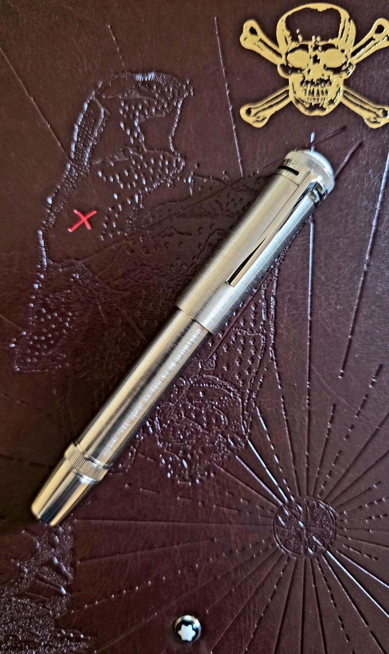 Peut inclure: Une tasse en c&eacute;ramique blanche avec une anse noire et le texte "But First, Coffee" en gras noir. La tasse est pos&eacute;e sur un fond flou, sugg&eacute;rant un cadre chaleureux.