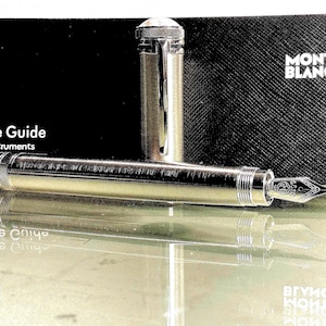 Peut inclure: Une tasse en c&eacute;ramique blanche avec une anse noire et le texte "But First, Coffee" en gras noir. La tasse est pos&eacute;e sur un fond flou, sugg&eacute;rant un cadre chaleureux.