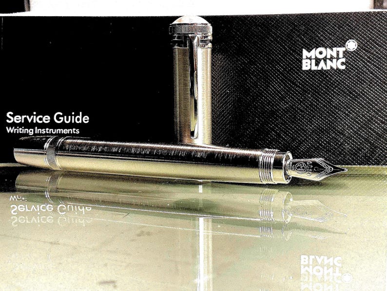 Peut inclure: Une tasse en c&eacute;ramique blanche avec une anse noire et le texte "But First, Coffee" en gras noir. La tasse est pos&eacute;e sur un fond flou, sugg&eacute;rant un cadre chaleureux.