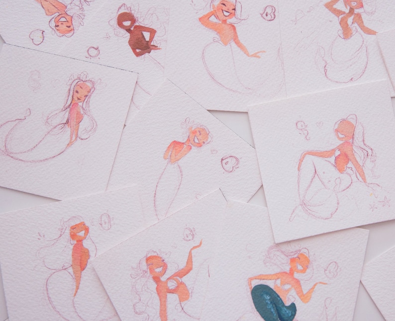 Puede incluir: Una colecci&oacute;n de ocho acuarelas de sirenas en papel blanco. Las sirenas est&aacute;n dibujadas en un estilo caprichoso con acentos rosas y rojos.