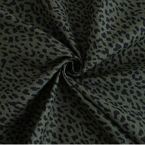 Peut inclure: Tissu vert avec un imprimé léopard noir. Le tissu est plié en forme de spirale.