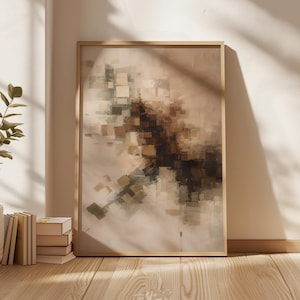 Op de afbeelding: Abstracte kunstafdruk in een houten lijst. Het kunstwerk toont een mix van beige, bruine en groene tinten, met een textuur, blokkerig ontwerp. De ingelijste kunst leunt tegen een muur, met zonlicht dat schaduwen op de houten vloer werpt.