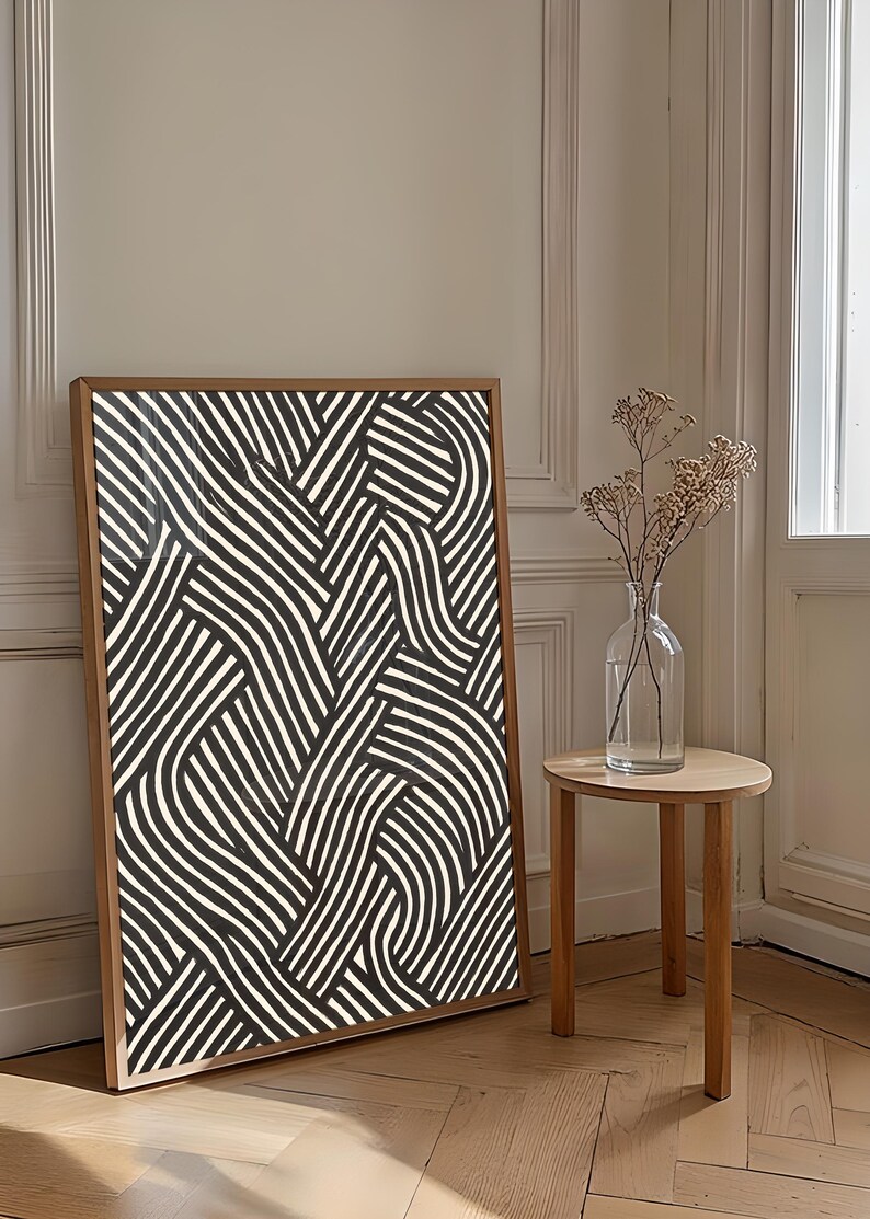 Black and white abstract line art poster featuring bold geometric striped patterns woven into a modern minimalist design on a beige background.