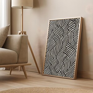 Black and white abstract line art poster featuring bold geometric striped patterns woven into a modern minimalist design on a beige background.