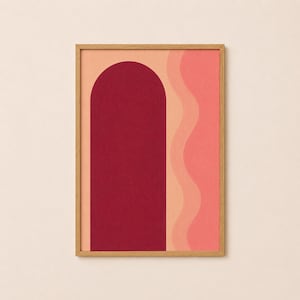 Op de afbeelding: Een ingelijste kunstdruk met een diepbordeauxrode boogvorm op een licht perzikkleurige achtergrond, vergezeld van verticale golvende lijnen in tinten lichtoranje en koraalroze. Het kunstwerk zit in een eenvoudige, lichtgekleurde houten lijst.
