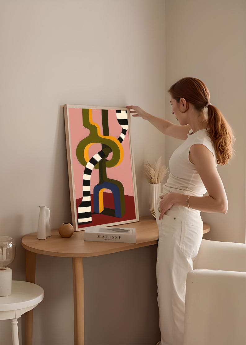 Contemporary abstract artwork featuring bold interlocking geometric shapes in olive green, gold, navy, and black-and-white stripes on a pink and red background.