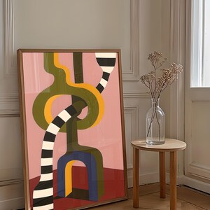 Contemporary abstract artwork featuring bold interlocking geometric shapes in olive green, gold, navy, and black-and-white stripes on a pink and red background.