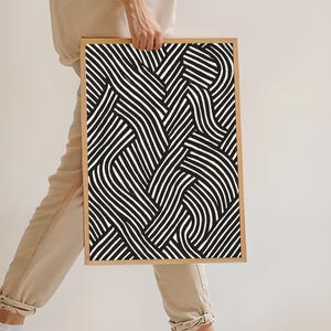 Black and white abstract line art poster featuring bold geometric striped patterns woven into a modern minimalist design on a beige background.