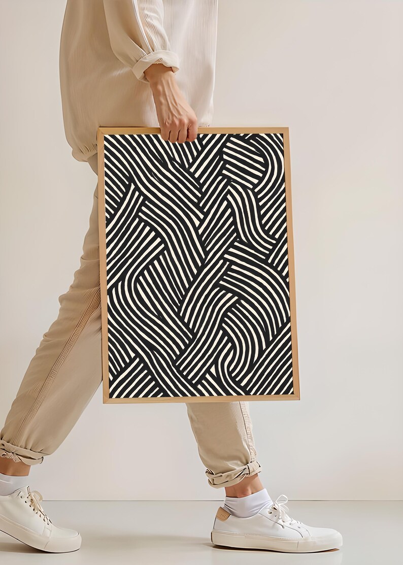 Black and white abstract line art poster featuring bold geometric striped patterns woven into a modern minimalist design on a beige background.
